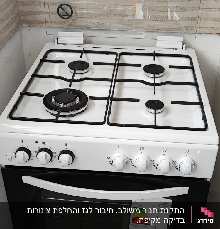תנור גז לבן עם ארבעה מבערים וכפתורי שליטה